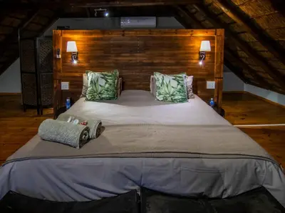 a bedroom with a large bed in a attic at The South Post @ Kruger in Marloth Park