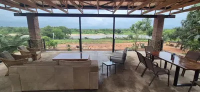 a living room with tables and chairs and a large window at The South Post @ Kruger in Marloth Park
