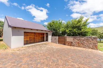 a house with a brick driveway in front of a garage at 109 Upwood in Dullstroom
