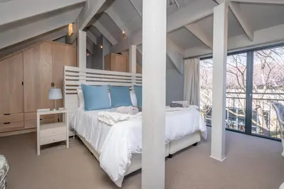 a bedroom with a white bed and a large window at 109 Upwood in Dullstroom