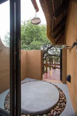 an outside view of a room with a round rug and a window at Naledi Lodges in Balule Game Reserve