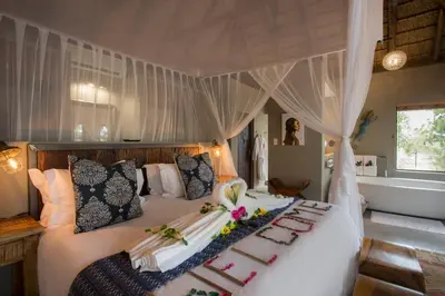 a bedroom with a bed with flowers on it at Naledi Lodges in Balule Game Reserve
