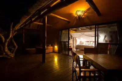 a room with a bed and a table and a table sidx sidx sidx at Naledi Lodges in Balule Game Reserve