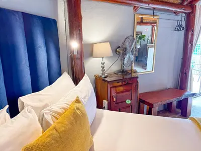 a bedroom with a bed and a mirror and a fan at @30 Zebra in Polokwane