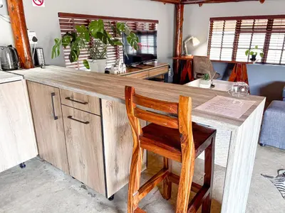 a wooden counter with a wooden chair and a desk at @30 Zebra in Polokwane