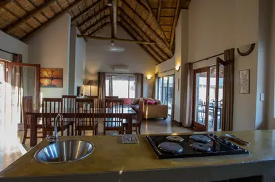 a kitchen and living room with a sink and a table at Igugu Lodge in Hoedspruit