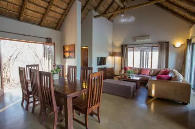 a living room with a table and chairs and a couch at Igugu Lodge in Hoedspruit