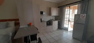 a kitchen with a refrigerator and a table in a room at 462 Bosbok Chalets in Marloth Park