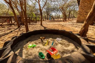 a sandbox with childrens toys in the sand at 462 Bosbok Chalets in Marloth Park