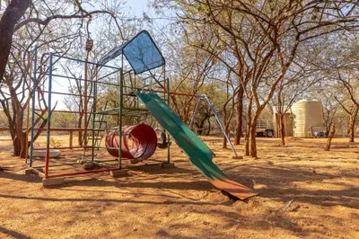 a playground in a park with a slide at 462 Bosbok Chalets in Marloth Park