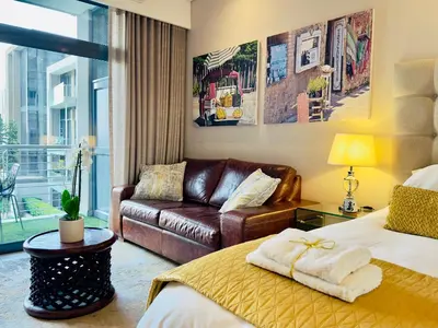a hotel room with a bed and a couch at Menlyn Maine Residences - Napoli with king sized bed in Pretoria
