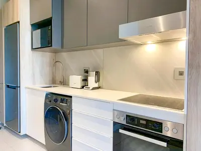 a kitchen with a washing machine and a sink at Menlyn Maine Residences - Napoli with king sized bed in Pretoria