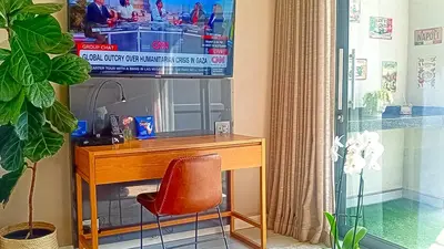 a desk with a television and a chair in a room at Menlyn Maine Residences - Napoli with king sized bed in Pretoria