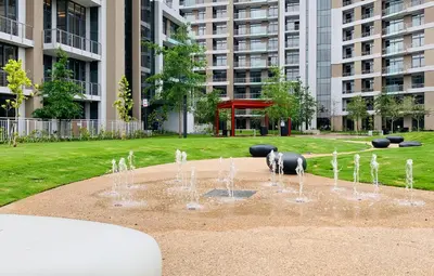 a fountain in a park in front of a building at Menlyn Maine Residences - Napoli with king sized bed in Pretoria