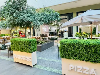 a restaurant with tables and chairs and an umbrella at Menlyn Maine Residences - Napoli with king sized bed in Pretoria