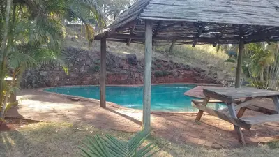 a picnic table under a pavilion next to a pool at Declan House in Louis Trichardt