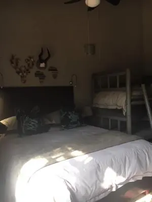 a bedroom with a large white bed and a fan at Vilagama Game Lodge in Naboomspruit