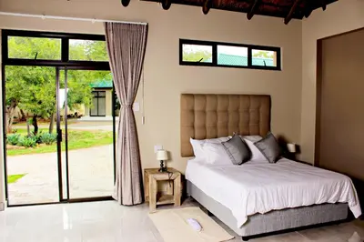 a bedroom with a bed and a sliding glass door at Zoe Bush Lodge in Pretoria