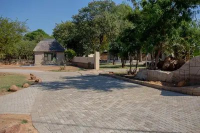 a brick walkway with a gazebo in a park at Zoe Bush Lodge in Pretoria