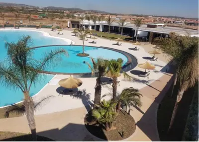 an overhead view of a swimming pool with palm trees and umbrellas at Alimama Spaces: The Manson's Blyde in Pretoria