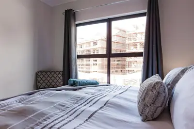 a bedroom with a bed and a large window at Alimama Spaces: The Manson's Blyde in Pretoria