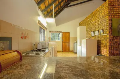 a large kitchen with a counter and a refrigerator at NJIRI - Your part of Africa in Marloth Park