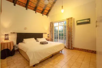 a bedroom with a bed and a large window at NJIRI - Your part of Africa in Marloth Park