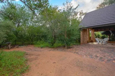 a brick pavilion with a table and chairs on a patio at NJIRI - Your part of Africa in Marloth Park