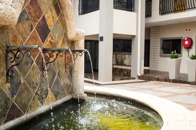 a water fountain in front of a building at The Wild Olive Guest House in Centurion