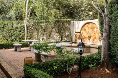 a garden with benches and a fountain and a street light at The Wild Olive Guest House in Centurion