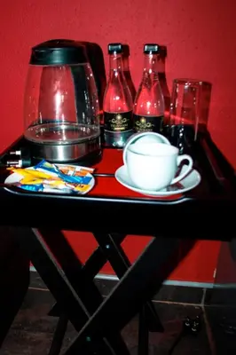 a table with a cup and four bottles of soda at Thavhani Guest House in Thohoyandou
