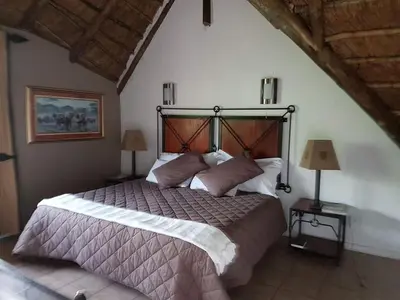 a bedroom with a large bed and two lamps at Bush Dream, Mabalingwe in Mabula