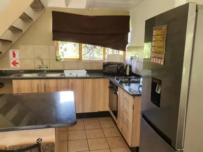 a kitchen with a sink and a stove top oven at Bush Dream, Mabalingwe in Mabula