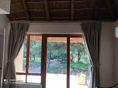 a window with gray curtains in a room at Bush Dream, Mabalingwe in Mabula