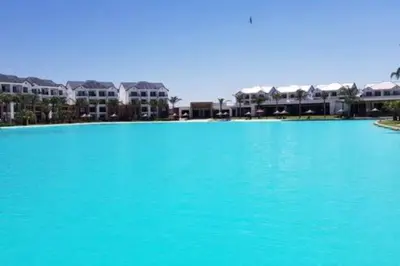 a large pool of blue water in front of houses at The Blyde - Beachfront in Pretoria