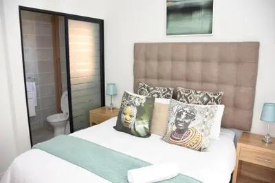 a bedroom with a bed with pillows on it at The Blyde - Beachfront in Pretoria
