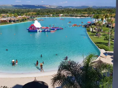 a large pool with people in the water at a resort at The Blyde - Beachfront in Pretoria