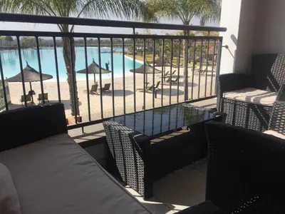 a balcony with chairs and a view of a pool at The Blyde - Beachfront in Pretoria