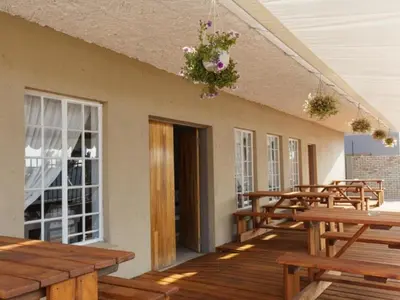 a row of wooden tables and benches on a deck at Mon Reve in Lephalale