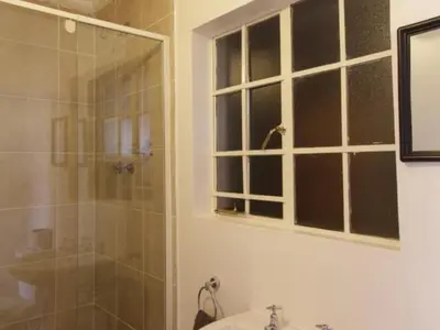 a bathroom with a shower and a sink and a glass door at Mon Reve in Lephalale