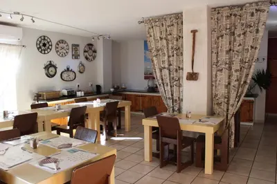 a restaurant with wooden tables and chairs and curtains at Mon Reve in Lephalale