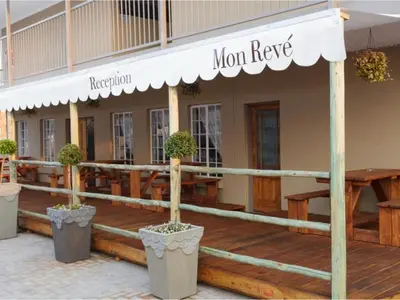 a restaurant with potted plants on the front of a building at Mon Reve in Lephalale