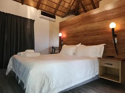 a bedroom with a large white bed with a wooden headboard at Elandsfontein 21, Mabalingwe in Mabula