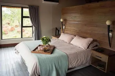 a bedroom with a large bed with a wooden headboard at Elandsfontein 21, Mabalingwe in Mabula