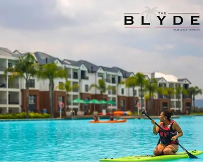a woman sitting on a paddle board in the water at The Blyde Riverwalk Estate in Pretoria