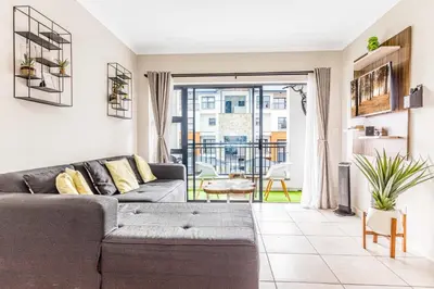 a living room with a couch and a balcony at The Blyde Riverwalk Estate in Pretoria