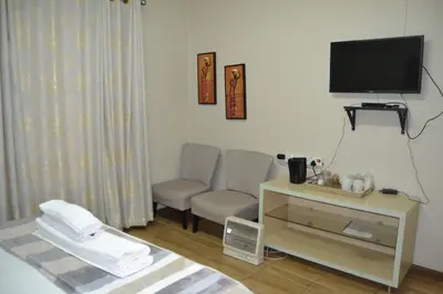 a living room with a television and a chair at Green Grove Villa in Centurion