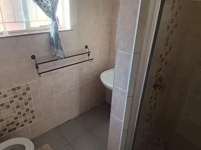 a bathroom with a toilet and a sink and a window at Home Sweet Home in Polokwane