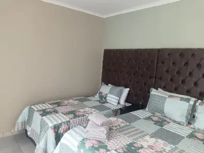 a bedroom with two twin beds and a headboard at Home Sweet Home in Polokwane