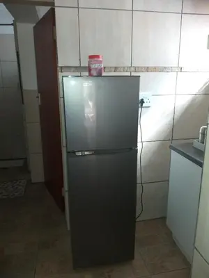 a black refrigerator with a red box on top of it at Home Sweet Home in Polokwane